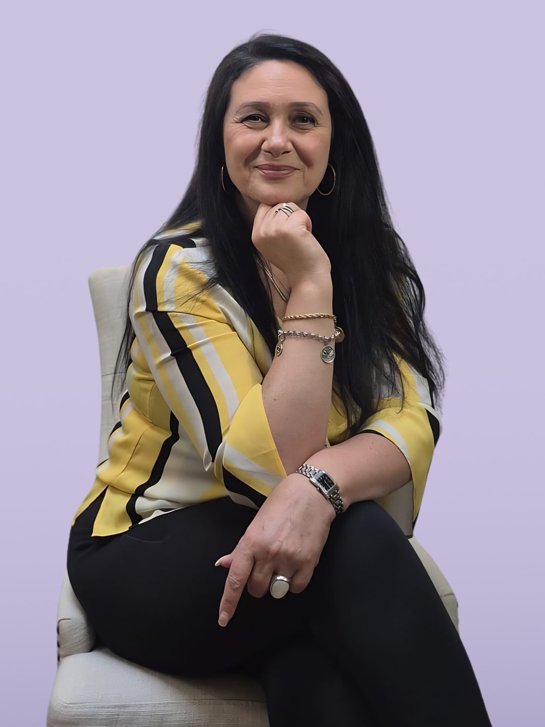 Rita Ditaranto seated, smiling, in a yellow striped blouse